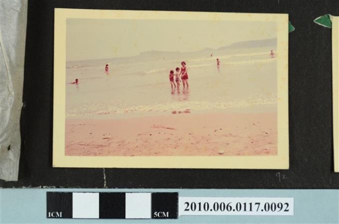 一女子與2位孩童在海邊戲水的照片 (共1張)
