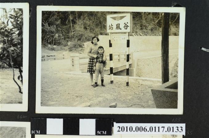 一女子與一男童站於谷風站車站牌前合影之照片 (共1張)